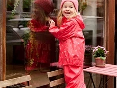 Pige i rødt CeLaVi regntøj med frugtprint 310453 4651 cayenne